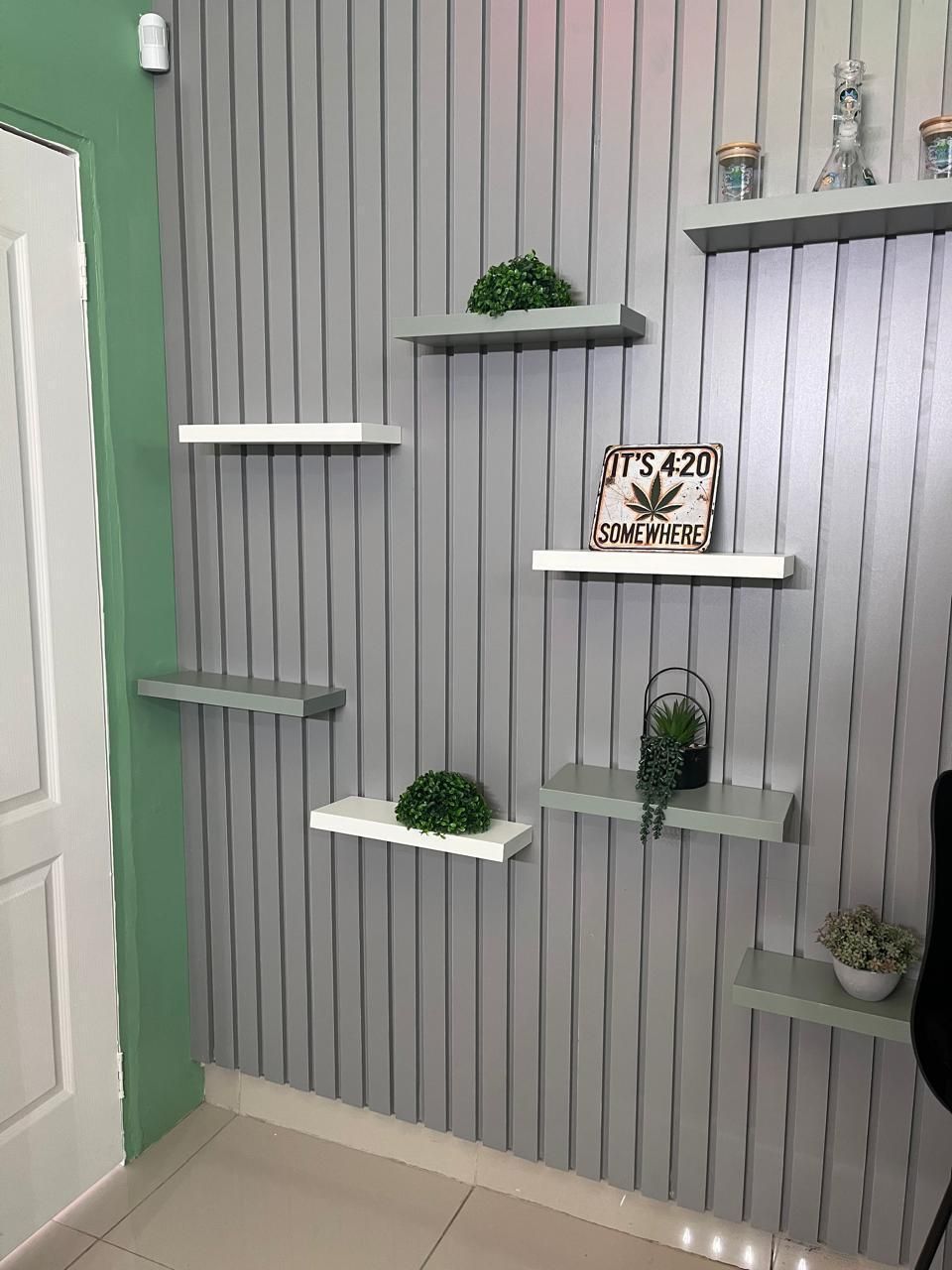 Floating shelves with plants and an It's 4:20 Somewhere sign at Niacanna